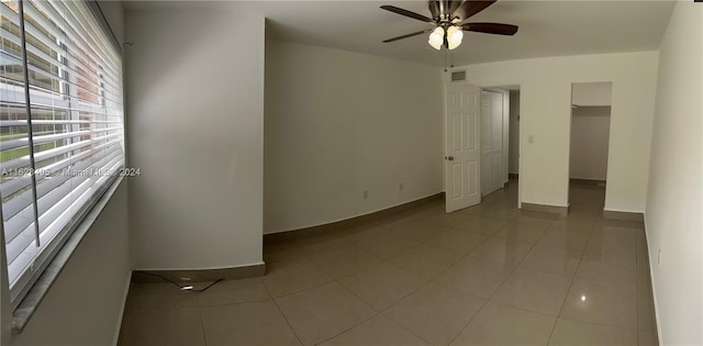 empty room with light tile patterned floors and ceiling fan