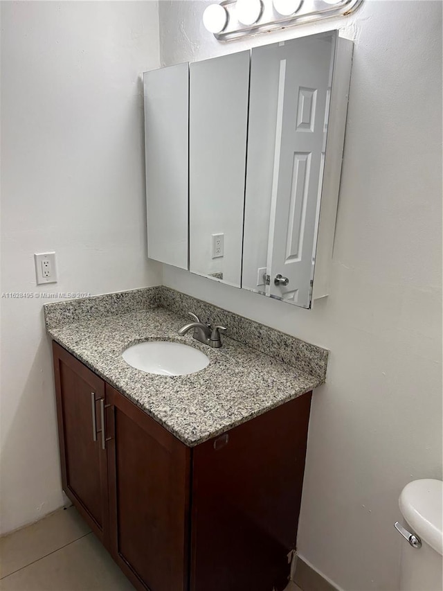 bathroom with vanity, toilet, and tile patterned flooring