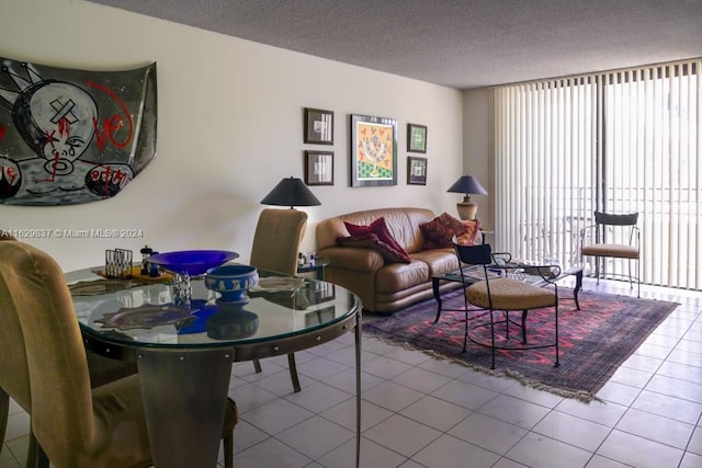 tiled living room with floor to ceiling windows and a textured ceiling