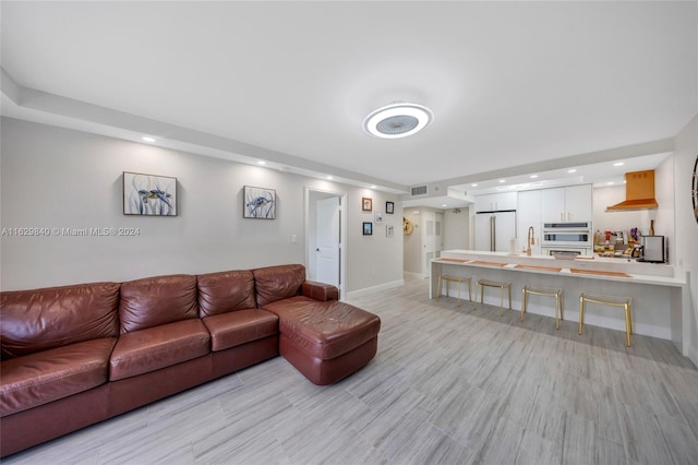 living room with light hardwood / wood-style floors and sink