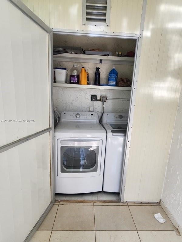 washroom featuring washer and clothes dryer and light tile patterned floors