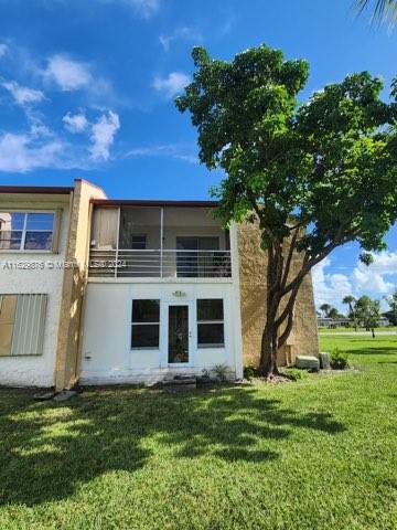 rear view of house with a balcony and a lawn