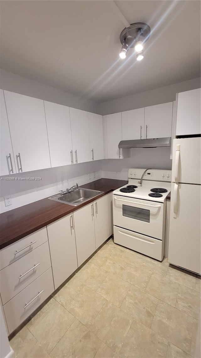 kitchen with sink, white cabinetry, light tile patterned floors, and white appliances