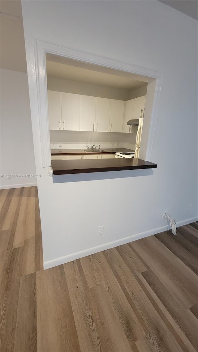 kitchen featuring sink, white cabinetry, and hardwood / wood-style floors