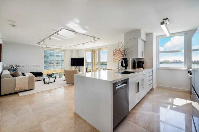 kitchen featuring white cabinets, dishwasher, modern cabinets, light countertops, and a sink