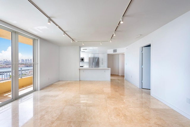 empty room with light tile patterned floors, french doors, and rail lighting