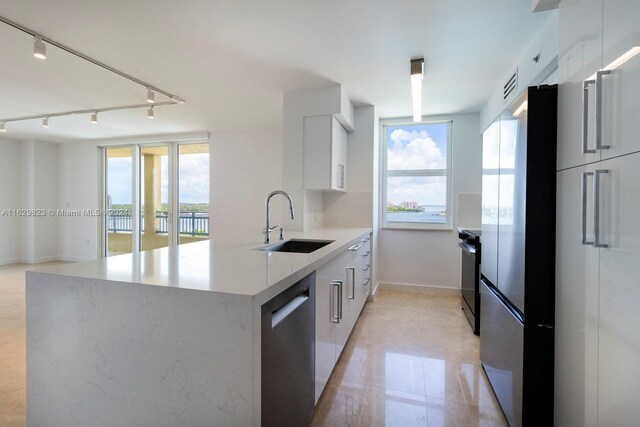 kitchen with kitchen peninsula, track lighting, light tile patterned flooring, stainless steel appliances, and sink