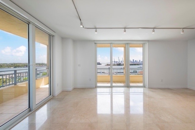 empty room featuring light tile patterned flooring and track lighting