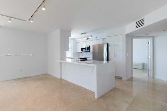 kitchen featuring visible vents, appliances with stainless steel finishes, white cabinetry, a sink, and a peninsula