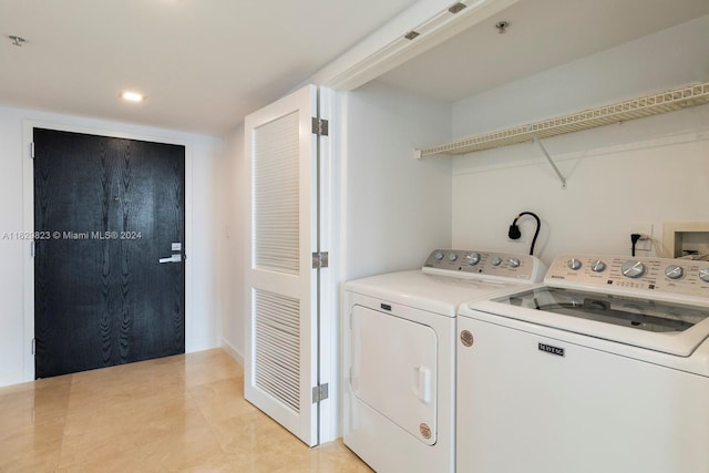 clothes washing area featuring light tile patterned flooring and washing machine and clothes dryer