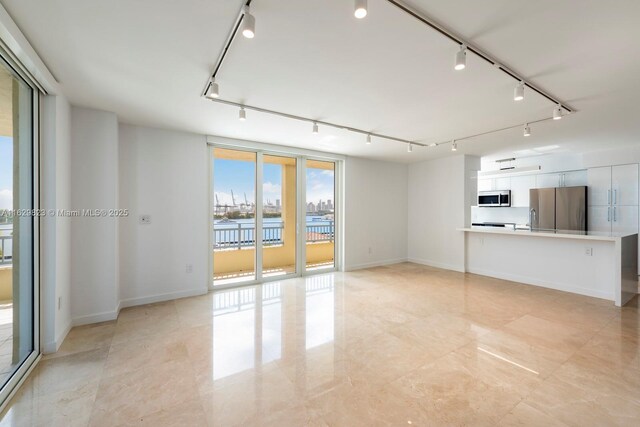 kitchen featuring stainless steel appliances, white cabinetry, light tile patterned flooring, tasteful backsplash, and sink