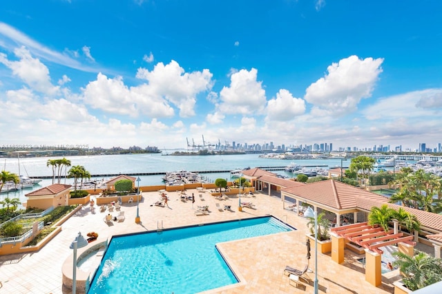 community pool featuring a water view, a view of city, and a patio