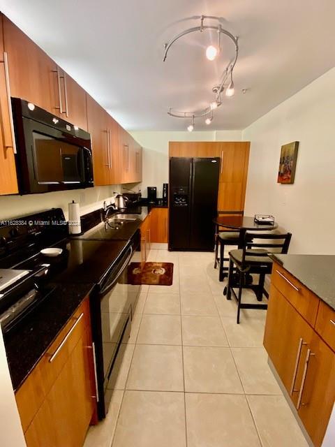 kitchen with light tile patterned floors and black appliances