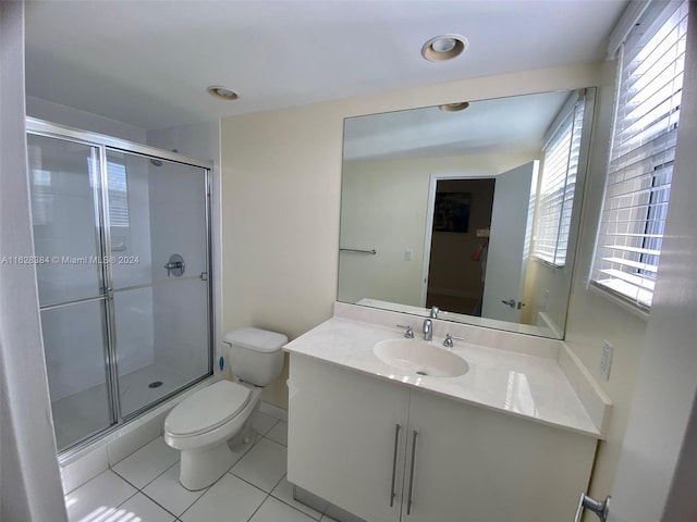 bathroom with tile patterned flooring, vanity, toilet, and a shower with door