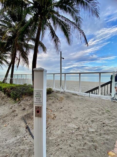 dock area with a water view and a beach view