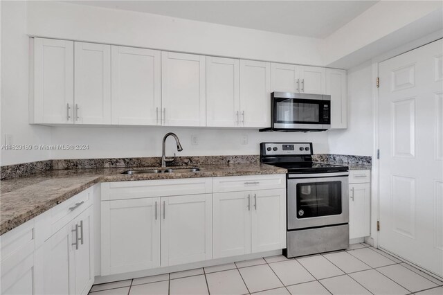 kitchen with sink, stone counters, white cabinets, and appliances with stainless steel finishes