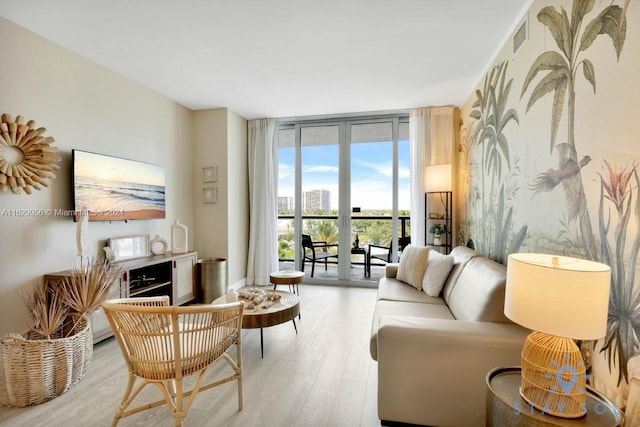 living area with light wood-style floors, visible vents, and floor to ceiling windows