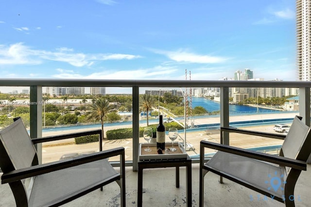 balcony featuring a view of city and a water view