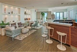 interior space featuring a dry bar and dark wood-style flooring