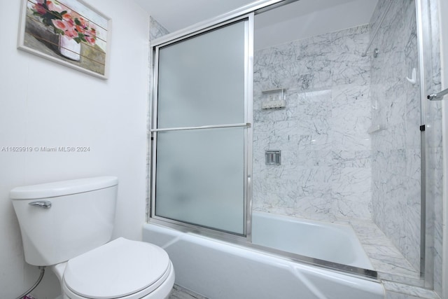 bathroom featuring combined bath / shower with glass door and toilet