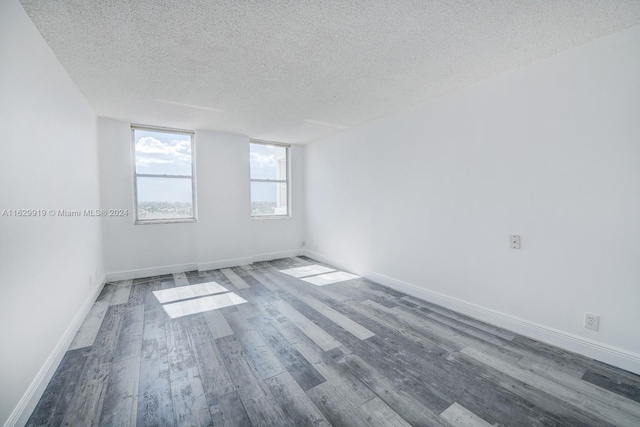 unfurnished room featuring hardwood / wood-style flooring and a textured ceiling