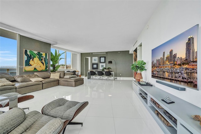 living room with light tile patterned floors and a wall of windows