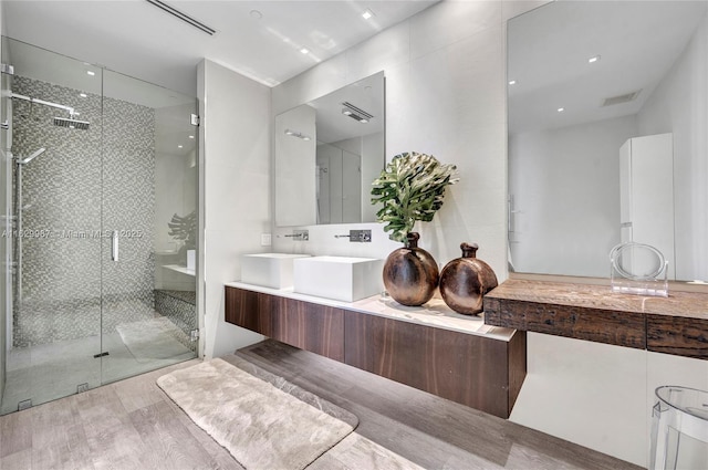 bathroom featuring hardwood / wood-style floors, vanity, and a shower with door