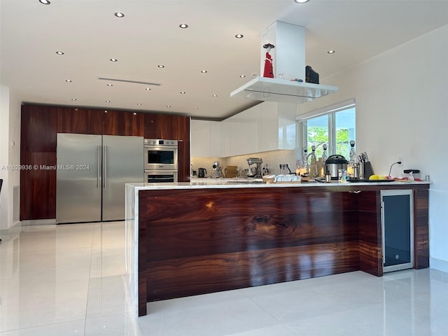 kitchen featuring white cabinetry, light tile patterned floors, stainless steel appliances, and tasteful backsplash