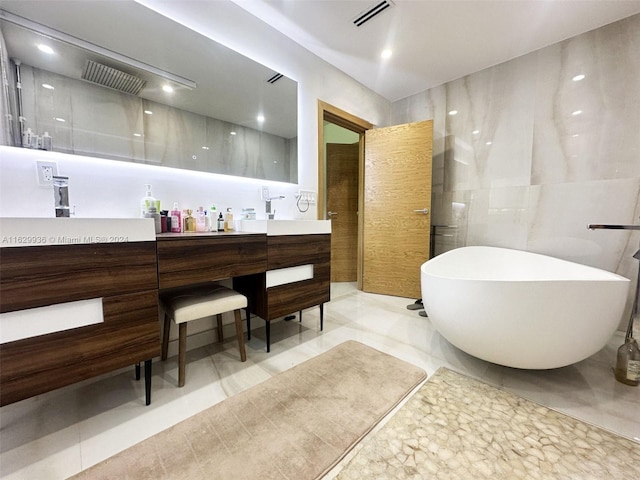 bathroom with shower with separate bathtub, vanity, tile patterned floors, and tile walls