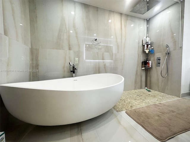 bathroom featuring plus walk in shower and tile walls