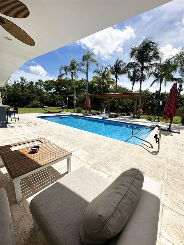 view of pool with a patio and ceiling fan