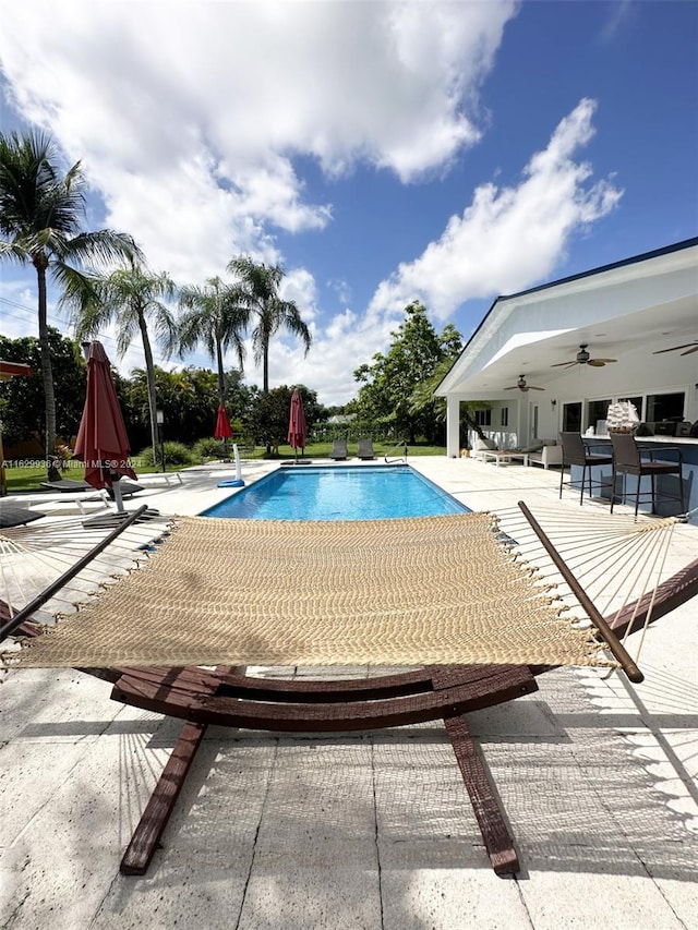 view of pool with a patio area and ceiling fan