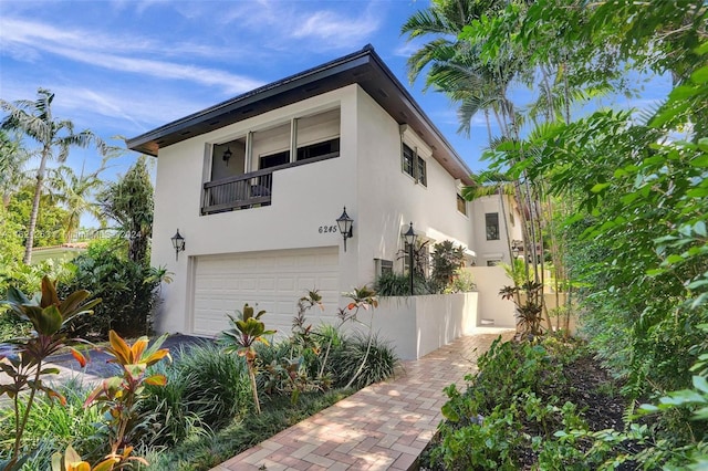 view of home's exterior featuring a garage and a balcony