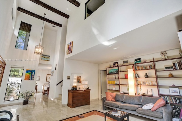 living room featuring a notable chandelier, beamed ceiling, and a high ceiling