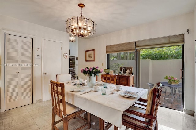 tiled dining room featuring plenty of natural light and a chandelier