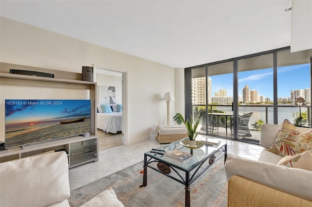 living room with a water view, a wall of windows, and light tile patterned flooring