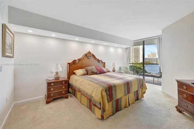 carpeted bedroom featuring a water view, floor to ceiling windows, and access to exterior