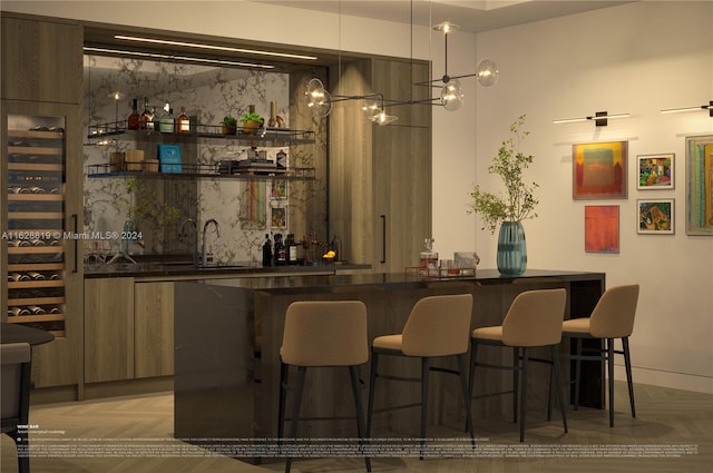 bar featuring sink, light parquet flooring, and decorative light fixtures