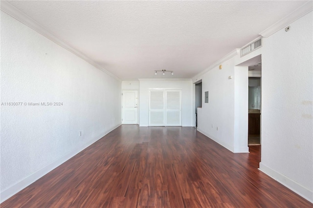 unfurnished room featuring dark hardwood / wood-style floors, ornamental molding, and a textured ceiling