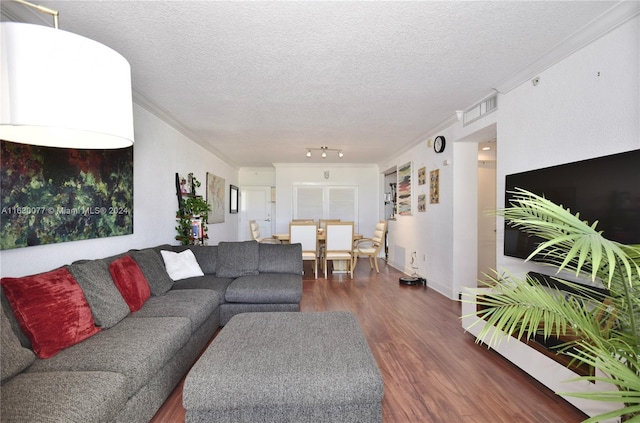 living room featuring a textured ceiling, dark hardwood / wood-style floors, and ornamental molding