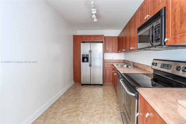 401 69th St Unit 411, Miami Beach, FL 33141 - kitchen featuring stainless steel appliances, light countertops, brown cabinets, and light tile patterned floors