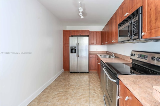 kitchen featuring appliances with stainless steel finishes, track lighting, sink, and light tile patterned floors