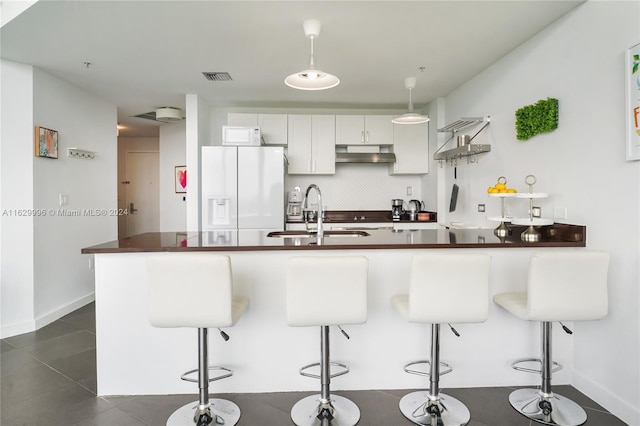 3301 NE 1st Ave Unit M0705, Miami, FL 33137 - kitchen with white refrigerator with ice dispenser, dark countertops, a sink, and under cabinet range hood