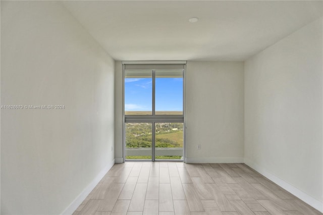 empty room featuring light hardwood / wood-style flooring and floor to ceiling windows