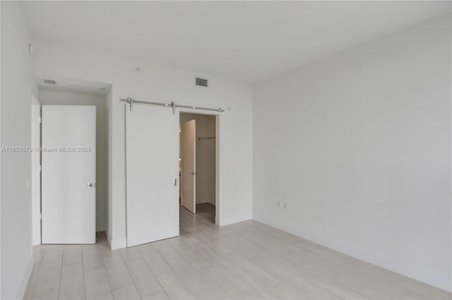 unfurnished bedroom featuring a barn door