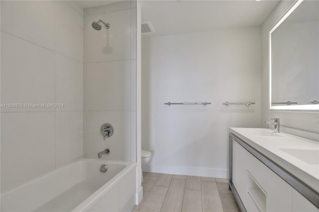 full bathroom with double vanity, tiled shower / bath combo, tile patterned floors, and toilet