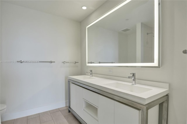 bathroom featuring double vanity, tile patterned flooring, and toilet