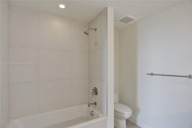 bathroom with toilet, tile patterned floors, and tiled shower / bath