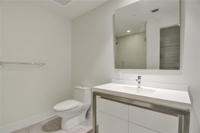 bathroom featuring tile patterned flooring, toilet, and vanity