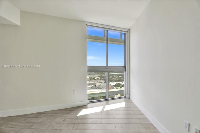 unfurnished room with a wall of windows